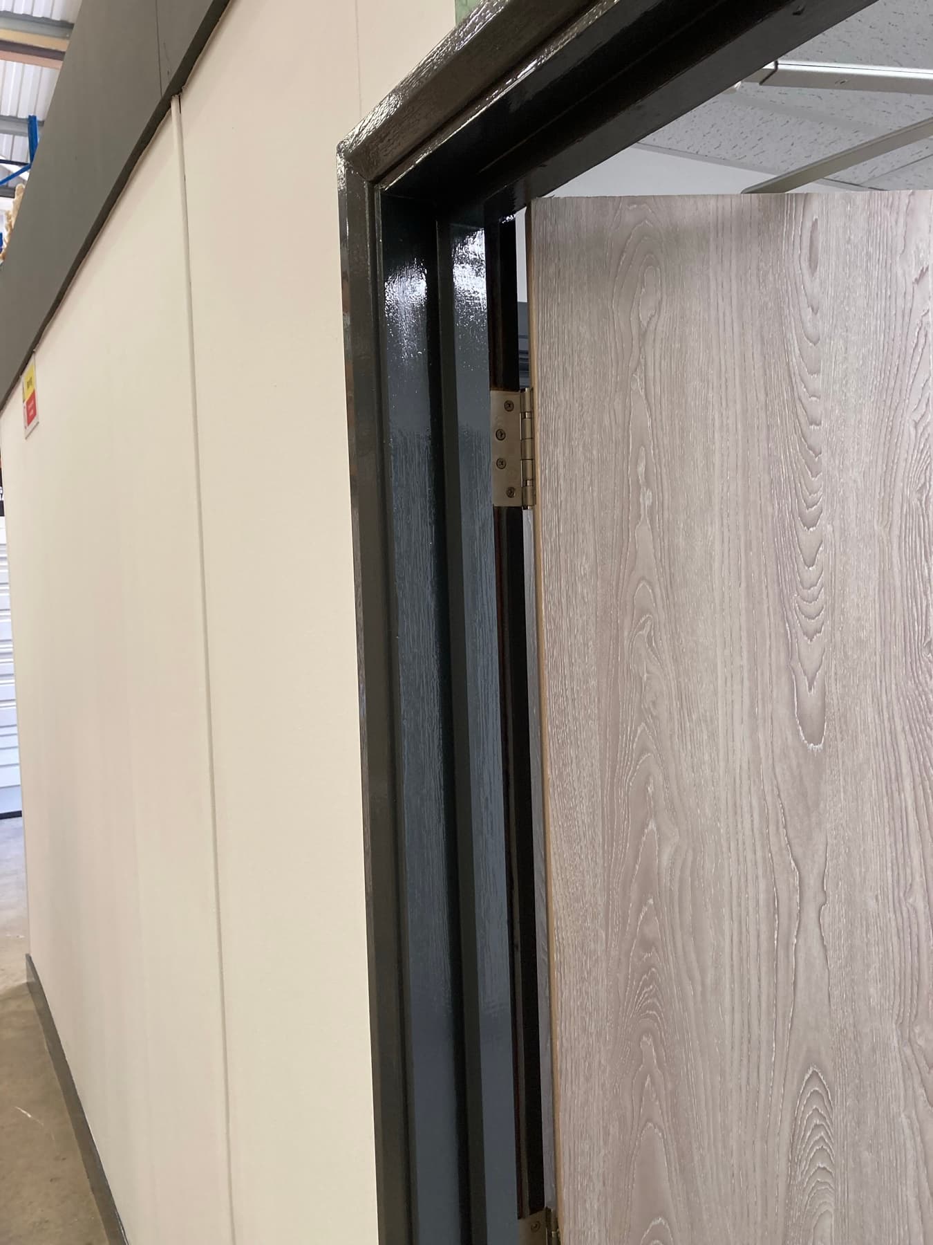 Slatted oak feature wall with bespoke worktop and high-contrast charcoal door frame
